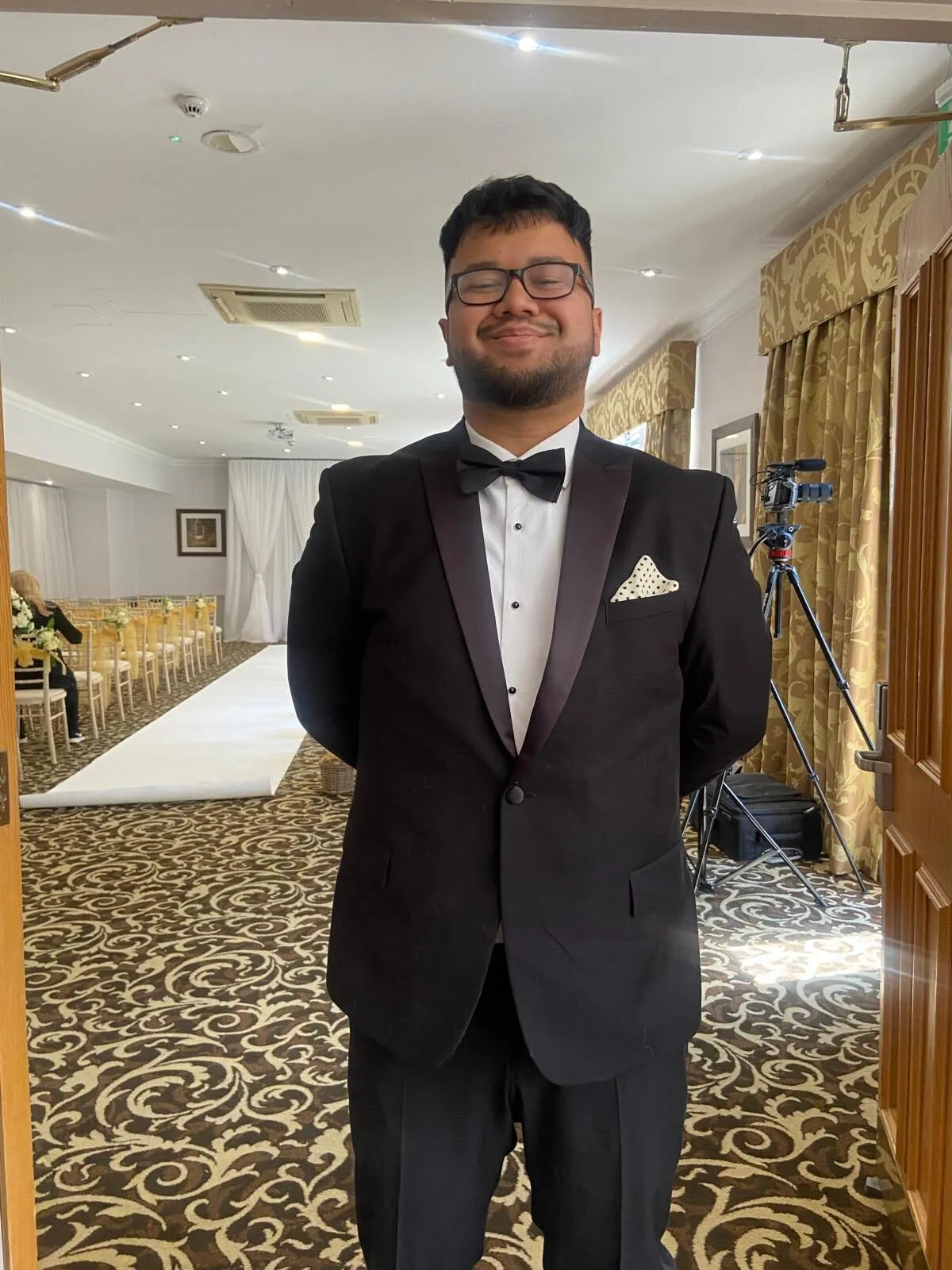A man in a tuxedo standing in a room.