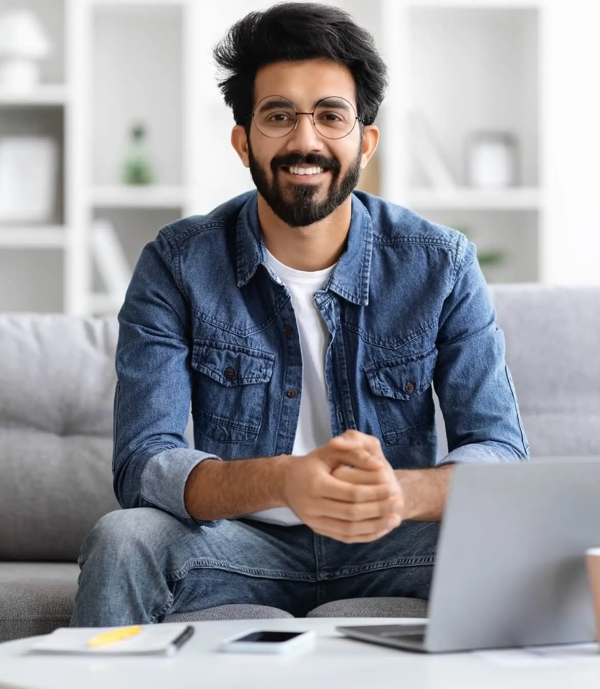 A man sitting on a couch with a laptop.