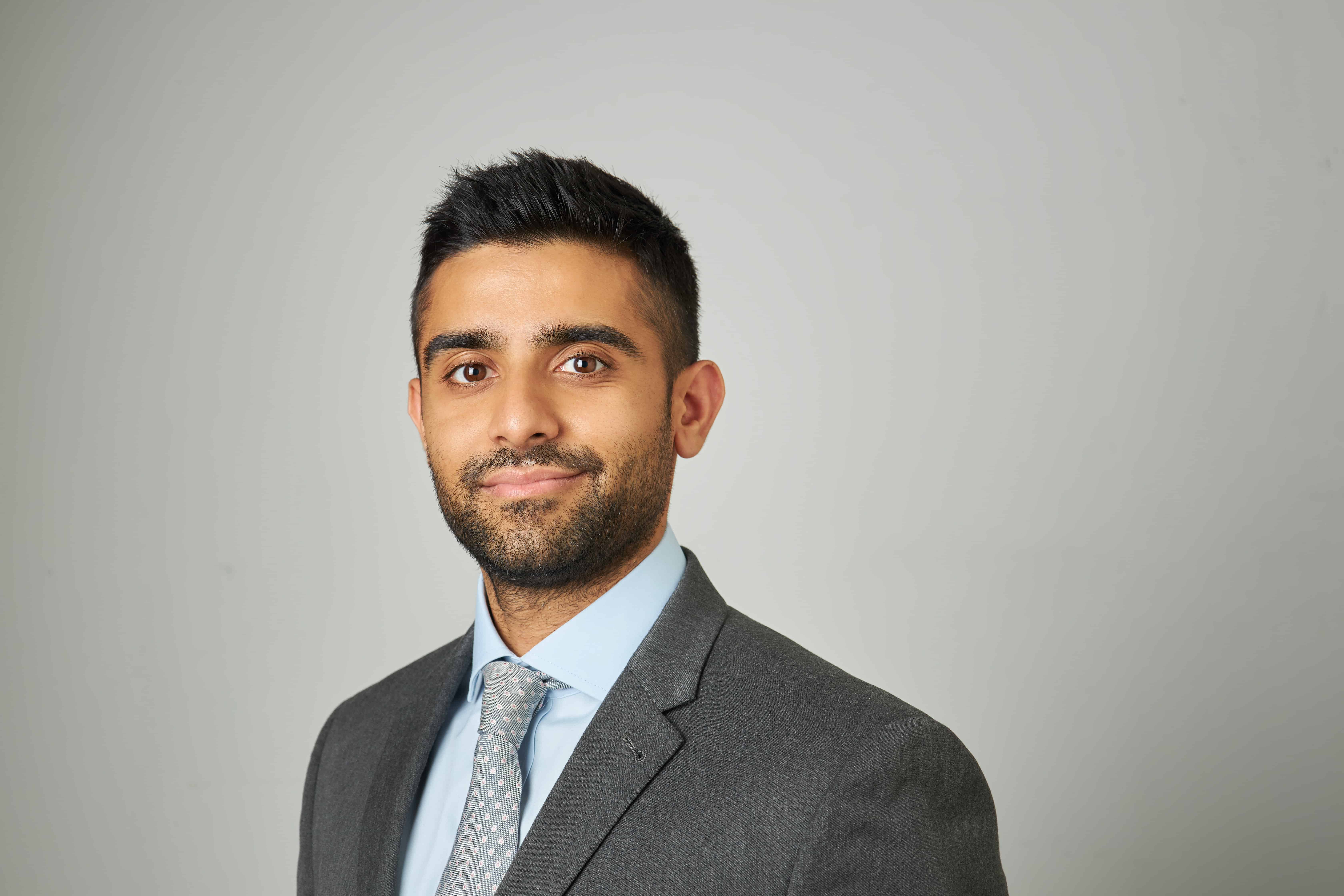A man in a suit and tie posing for a picture.